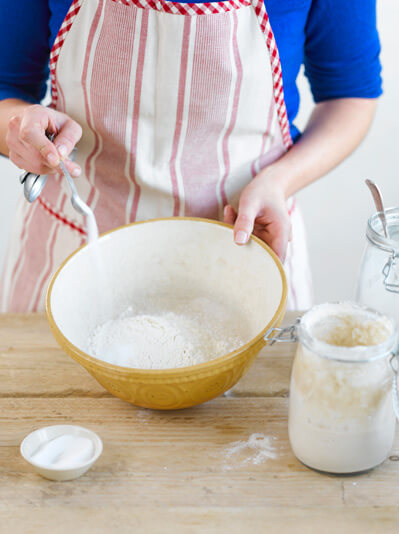 Image of flour and salt being mixed in a bowl to make sponge for sourdough