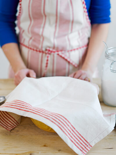 Image of sourdough mixture covered with a tea towel to rise